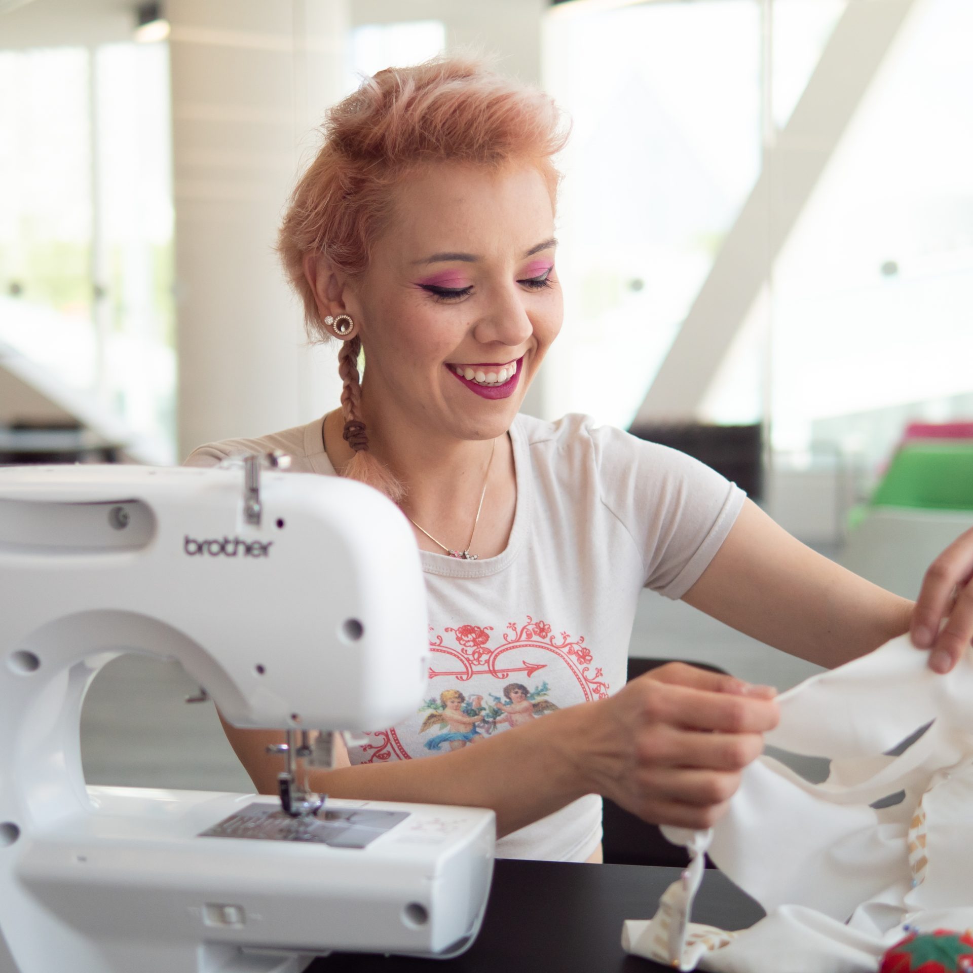 Sewing_Customer-4 A person smiling while using the sewing machine